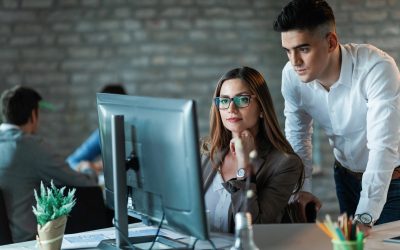 Two young entrepreneurs working on a computer and reading an e-mail in the office.